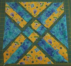 the block is made up of blue and yellow fabric, with flowers on each side