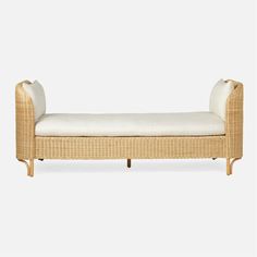 a wicker chaise lounge with white cushions on the top and bottom part of it