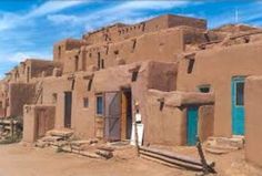 an adobe style building with blue doors and windows