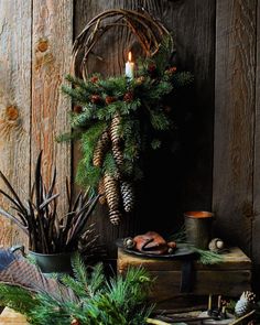 an arrangement of evergreens, pine cones and other holiday decorations