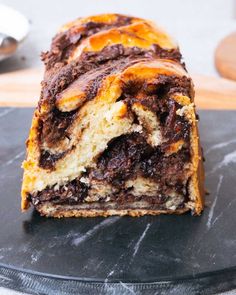 a piece of chocolate marble cake sitting on top of a black plate