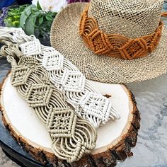 two hats sitting on top of a wooden log next to flowers and other items in the background