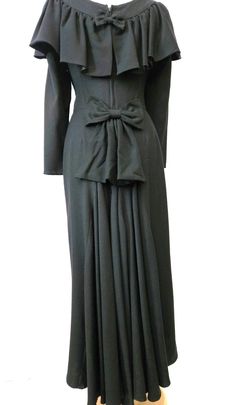 Vintage 1990's  wool crepe long dress.  Unique design with a gathered cape style collar over the shoulders across the back. A slim sheath with a fish tail skirt. Bows attached  by snaps can be removed. The fabric is a soft wool  Styled and made in Canada. In excellent condition one previous owner * Measurements.  Bust 35" Waist  32" Hips 38" Length shoulders to hem 50"  Side seams 1/2" total let out. * Care Dry Clean Cape Style, Black Wool, Victorian Fashion, Dress Clothes For Women, Long Dress, Victorian Dress, Dress Outfits, Unique Designs, Formal Dresses