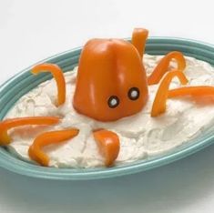 an orange octopus on top of whipped cream in a blue bowl with white frosting