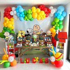 a table filled with balloons and decorations for a charlie the pooh birthday party at home