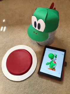 a green hat sitting on top of a table next to a tablet