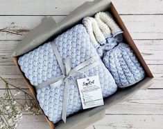 three baby blankets in a box with a tag on the front and side, tied together