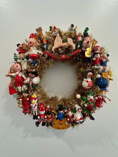 a christmas wreath is hanging on the wall next to a white wall and there are many ornaments around it