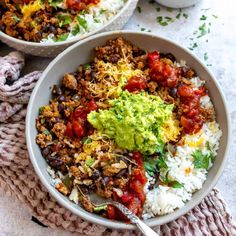 two bowls filled with rice, beans and guacamole on top of a table