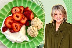 a woman standing in front of a plate of food with strawberries and cream on it