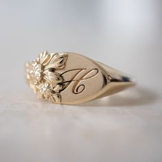 This vintage-inspired floral ring is a row of dainty flowers wrapped around your fingers. Handmade and polished, it is available in solid 8K and 14K gold. This item is engravable with text or monogram of your choice at no extra cost. The initals are engraved onto the ring and embedded in the 3D model for a flawless embossed finish. It is also possible to add a diamond or birthstone or diamond to this ring at an additional fee. Please inquire for details. A few notes about our gold: - Though we d Signet Engagement Rings, Big Diamond Engagement Rings, Ring Size Chart, Couple Ring Design, Dainty Flowers, Diamond Signet Ring, Engraved Ring, Signet Rings, Gold Monogram