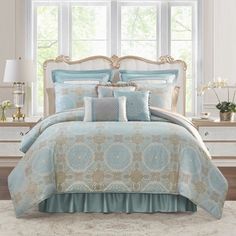 a bed in a bedroom with blue and gold comforters