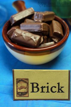 a bowl filled with lots of chocolate next to a sign that says brick on it