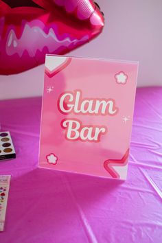 a close up of a sign on a table near some balloons and other items in the background