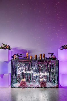 an image of a stage set up for a wedding reception with purple lighting and flowers