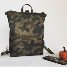 "Camo Military backpack and crossbody bag. The vegan minimalist bag is AVAILABLE in more sizes. Ideal and unique backpack as your everyday bag - travel bag, work bag, netbook bag, shopping bag. DETAILS - outer zippered pocket front and back - laptop pocket (non padded) - 2 inside open pockets - inside zipper pocket - zipper closure - metal parts antique brass MATERIALS - outer: camo WATERPROOF CORDURA fabric (100%PES) - internal: green canvas - antique brass metal hardwer - green thread This bag Multifunctional Khaki Backpack For Everyday Use, Casual Travel Backpack In Camouflage, Khaki Nylon Backpack For Everyday Use, Functional Khaki Backpack For Everyday Use, Camouflage Backpack For Outdoor Activities, Functional Camouflage Bags For Everyday Use, Camouflage Functional Travel Bags, Casual Camouflage Travel Backpack, Functional Camouflage Travel Bag