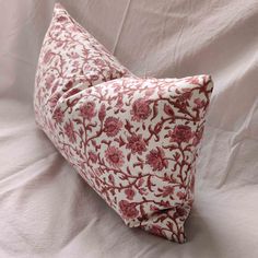 two red and white pillows sitting on top of a bed