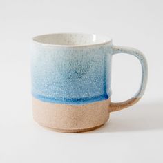 a blue and white coffee cup sitting on top of a table