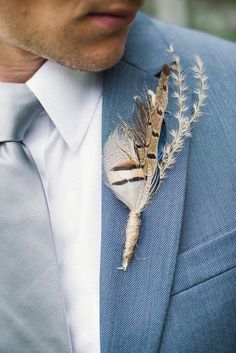 a man wearing a suit and tie with a boutonniere on his lapel