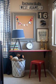 an image of a room with pictures on the wall and a lamp in the corner