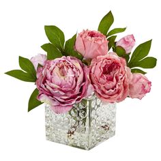 three pink flowers in a square glass vase with green leaves on the top and bottom