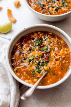 two bowls filled with chili and cheese soup