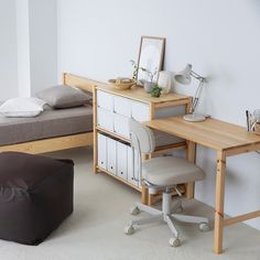 a bedroom with a bed, desk and chair next to a small ottoman on the floor