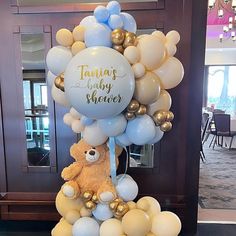 there is a teddy bear on top of balloons