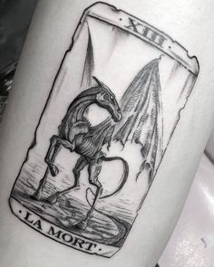 a black and white photo of a tattoo with a dragon on it's arm