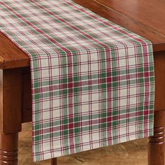 a plaid table runner on top of a wooden table