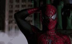 a man in a spider - man suit is posing for the camera with his hands behind his head