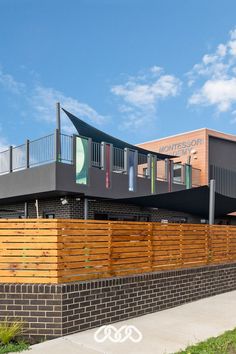 Childcare centre street view with timber fence and coloured glass panels Daycare Design, Glass Fence, Tinted Glass