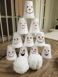 there are many snowmen that have been made out of paper cups on the table