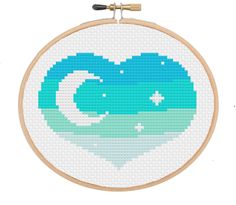 a cross stitch pattern with the shape of a heart in blue and green water on a white background