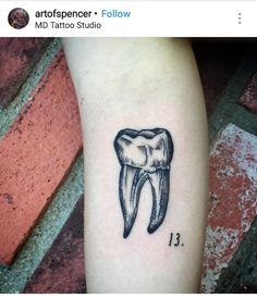 a black and white drawing of a tooth on the arm