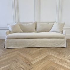 a white couch sitting on top of a wooden floor