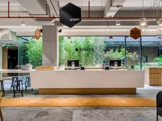 an office with tables and chairs in front of large windows