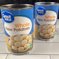 two canisters of whole new potatoes sitting on a kitchen counter with white tile