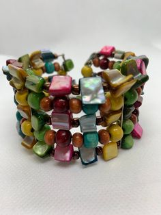 Mother of Pearl Rainbow Cuff Dyed Mother Of Pearl Beads Wood and Glass Beads Pride Colors Festival Bracelet This Is A Used Item In Condition Bohemian Multicolor Bracelets With Polished Beads, Bohemian Beaded Pearl Bangle Bracelet, Bohemian Multicolor Adjustable Pearl Bracelet, Bohemian Beaded Cuff Bracelet For Beach, Multicolor Round Beads Cuff Bracelet, Adjustable Multicolor Cuff Bracelet With Large Beads, Multicolor Beaded Cuff Bangle Bracelet, Artisan Multicolor Wooden Beaded Bracelets, Bohemian Multicolor Round Beads Cuff Bracelet