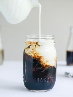 a mason jar filled with liquid sitting on top of a table