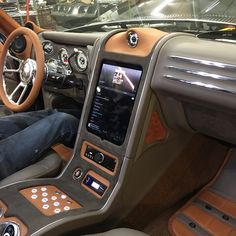 a man sitting in the driver's seat of a car with his feet on the steering wheel