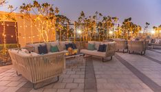 an outdoor seating area with lights and palm trees