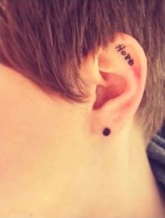 a person with a tattoo behind their ear