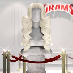 a white wig on display in front of a red ribbon