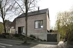 the house is made of brick and has two garages on each side, along with a driveway