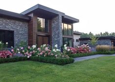 a house with flowers in front of it and landscaping around the windows on both sides