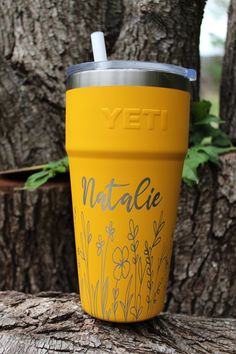 a yellow yeti cup sitting on top of a tree