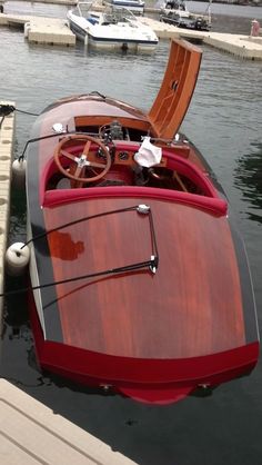 a red and black boat docked at a dock