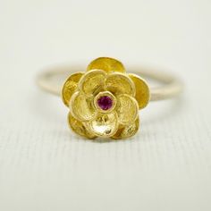 A vibrant pink sapphire is a central focal point with textured petals and a little polish for contrast. Raised high enough to leave room for stacking with other bands. She's beautiful in yellow, white or silver. genuine pink Sapphire Round Brilliant Diamond Duo metal combinations Yellow or Rose Gold Band in sterling silver Rounded or flat band Ready to ship: R1 - 18k Yellow Gold flower w/ pink sapphire - Sterling Silver Rounded band with a matte finish in size 6 R2 - 14k Rose Gold flower w/ diam Pink Ruby Flower-shaped Jewelry, Flower Shaped Ruby Ring As A Gift, Flower Shaped Ruby Ring In Yellow Gold For Wedding, Flower-shaped Yellow Gold Ruby Ring For Wedding, Yellow Gold Ruby Ring For Wedding With Flower Shape, Yellow Gold Flower Ruby Ring For Wedding, Gold Ruby Flower Ring, Fine Jewelry Ruby Ring With Flower Shape, Fine Jewelry Flower-shaped Ruby Ring Gift