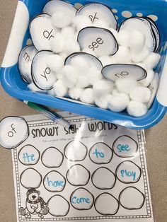 a blue bowl filled with snowballs next to a white and blue container full of snowballs